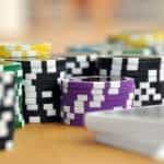 Stacks of poker chips next to a deck of cards.