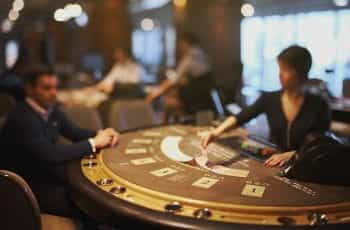 A blackjack dealer lays out her cards on a card table.