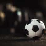 A lone soccer ball rolls against an indistinct background.