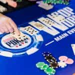 Players sit around a World Series of Poker branded table.