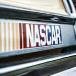 The world-famous NASCAR logo emblazoned on a bumper sticker placed on the back of a car.